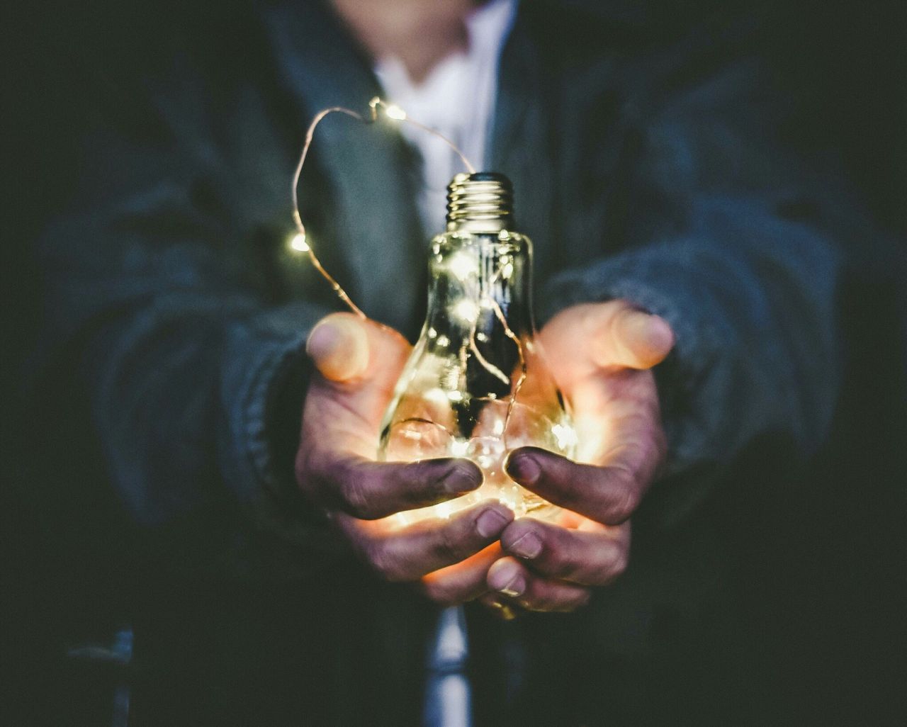 Person holding a lightbulb.