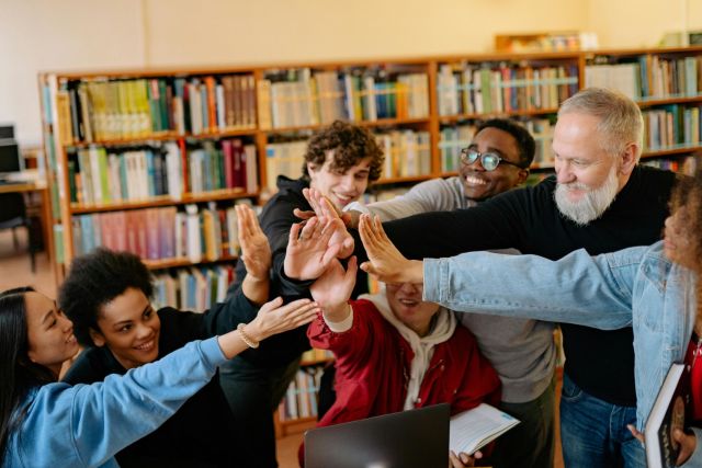 Students giving high fives with a teacher.