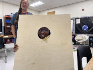 Student working on a cornhole board.
