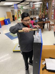 Student working on a cornhole board.