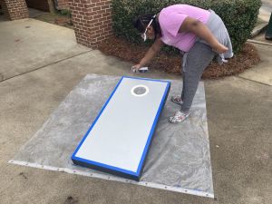 Student working on a cornhole board.