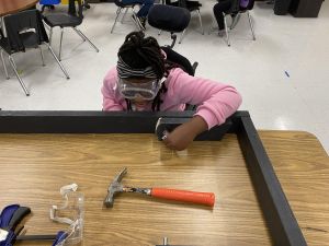 Student working on a cornhole board.