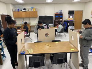 Student working on a cornhole board.