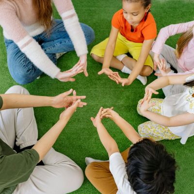 Children and Teachers sitting in a circle together.