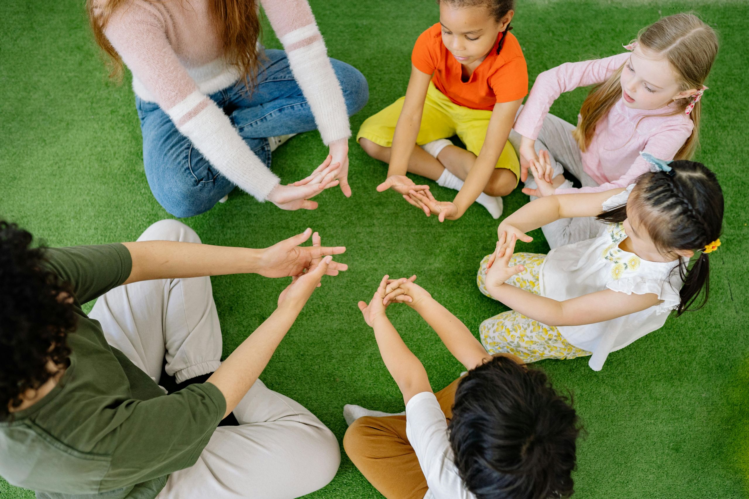 Children and Teachers sitting in a circle together.