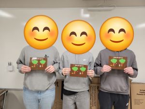 Students holding their own children's book they wrote.