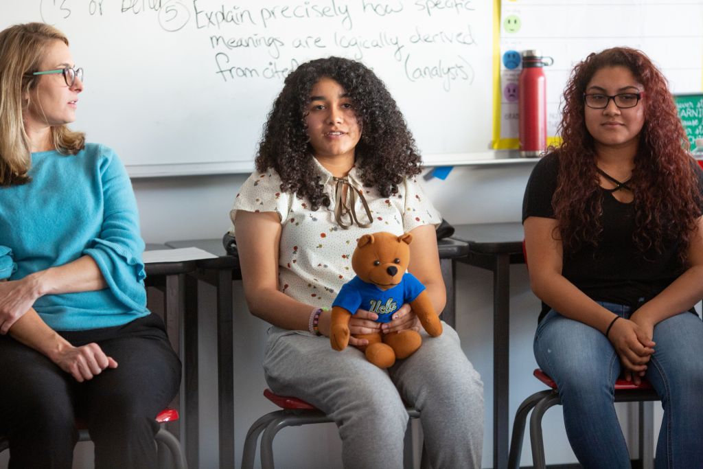 A high school student introduces herself to her classmates and guests in an AP research class.