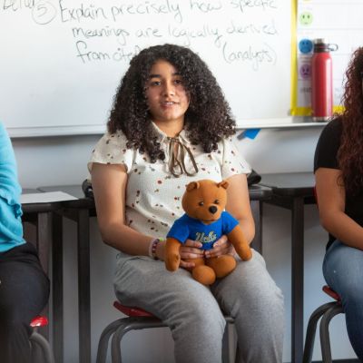 A high school student introduces herself to her classmates and guests in an AP research class.