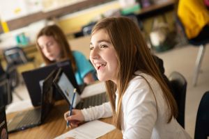 A sixth-grader smiles during class after answering a question correctly.