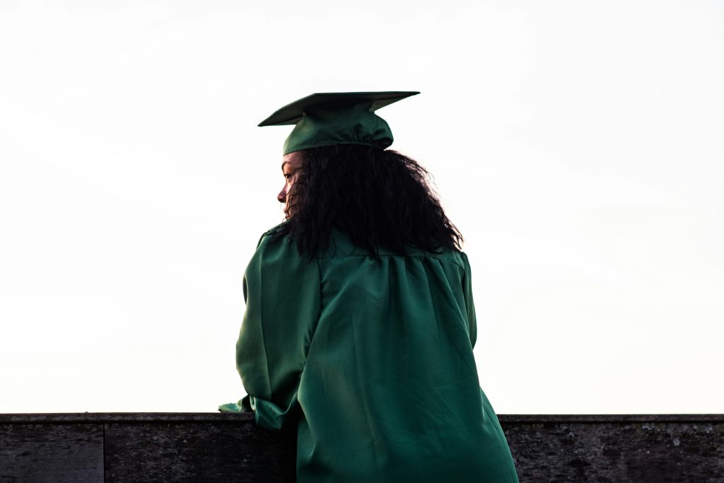 Person standing in their graduation cap and gown.