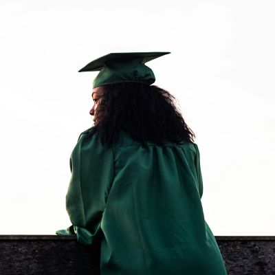 Person standing in their graduation cap and gown.