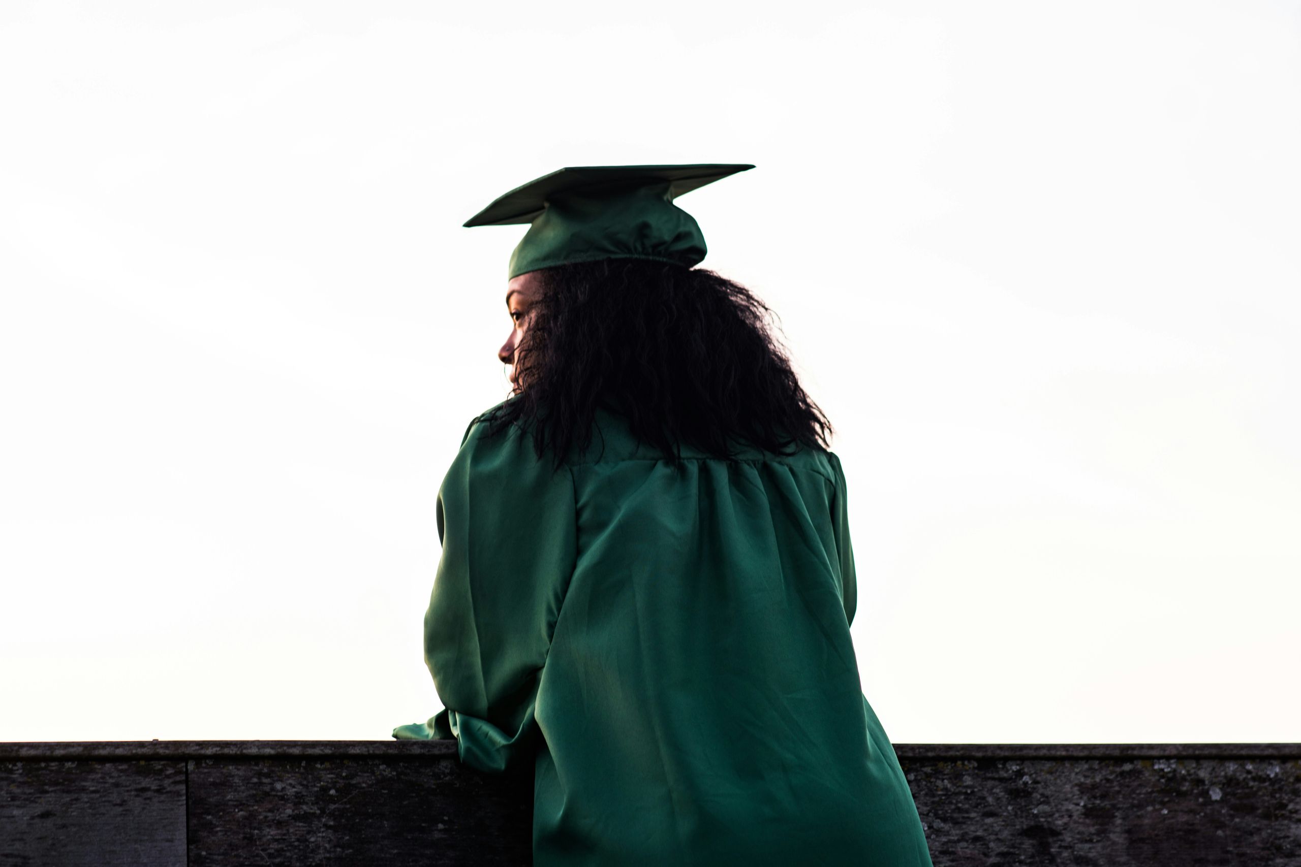 Person standing in their graduation cap and gown.