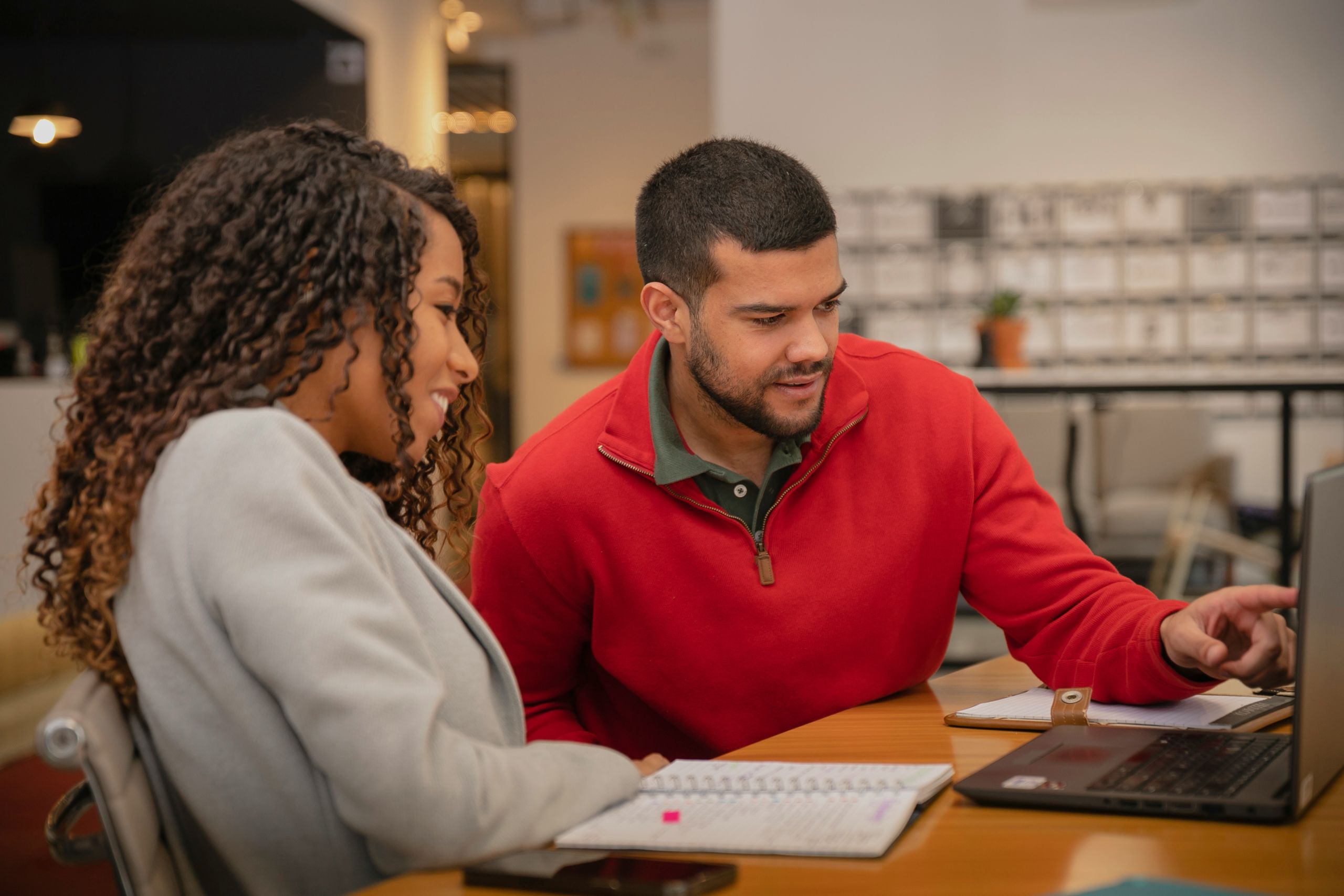 April 2026 cover Two people talking over a laptop.