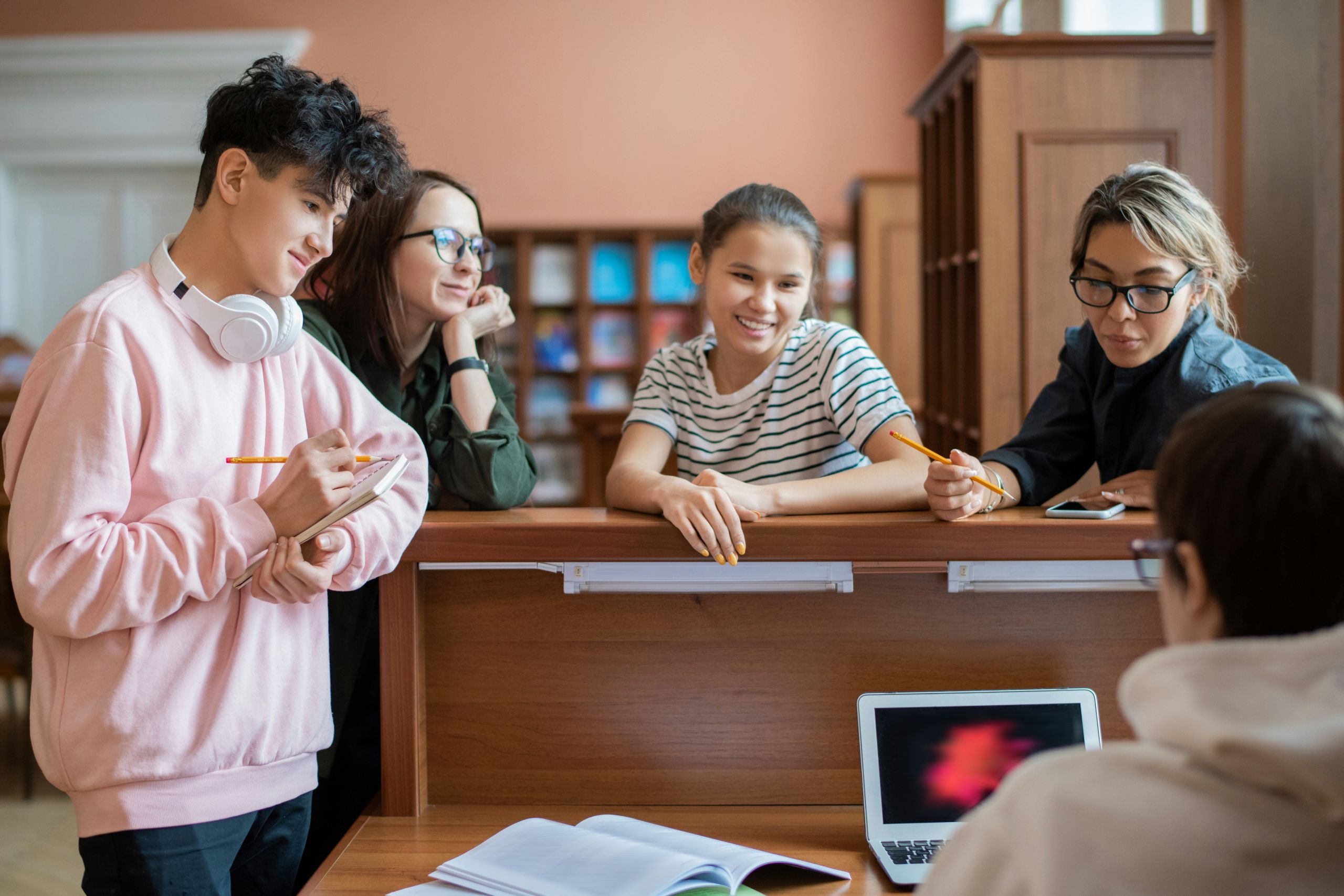 Students asking a question in a library.