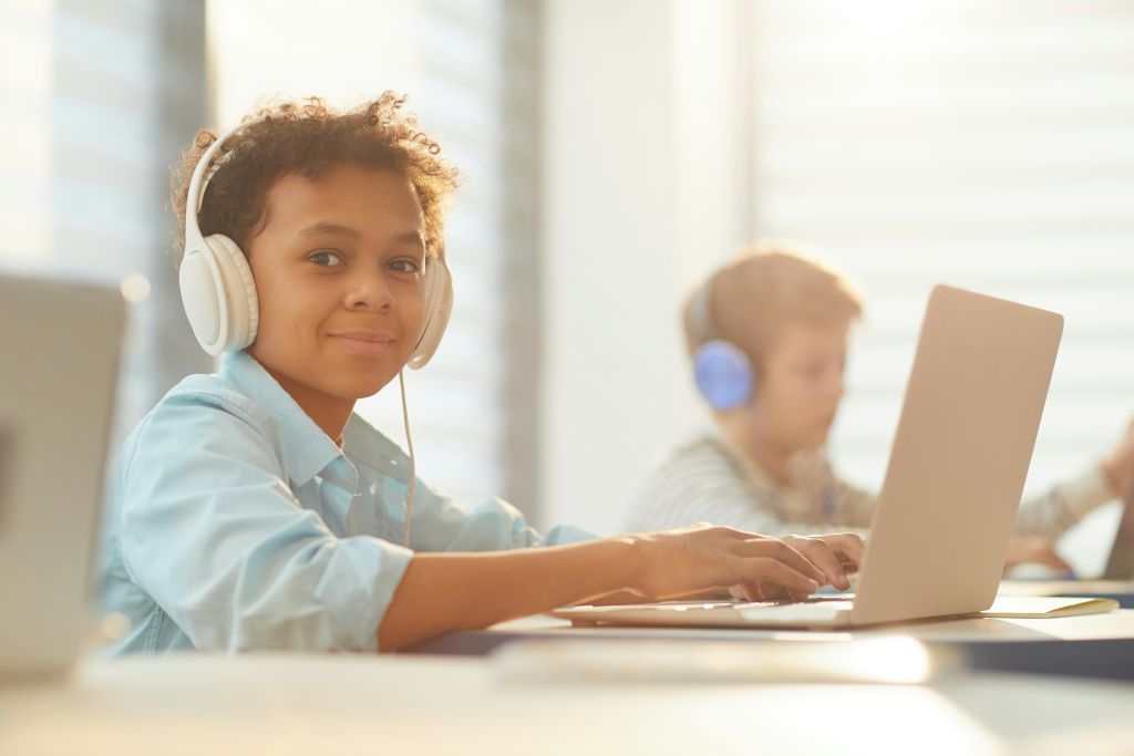 Student using a laptop and using headphones.