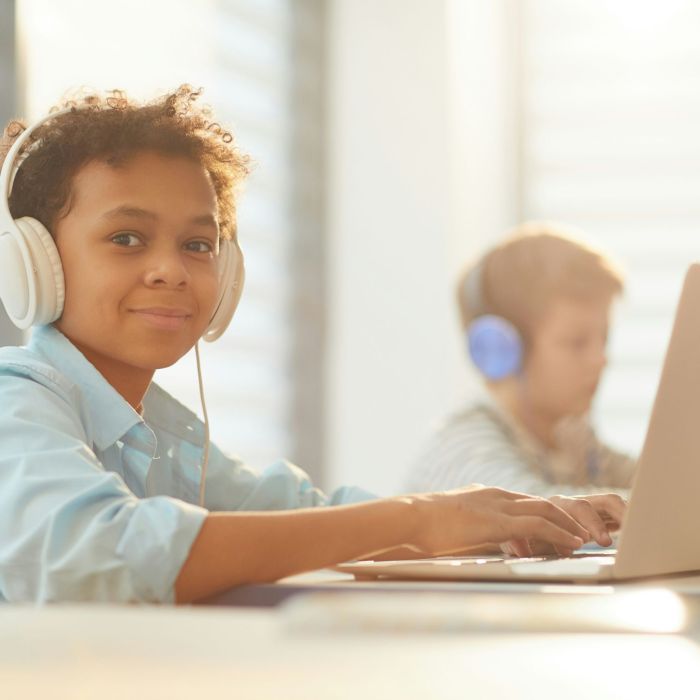 Student using a laptop and using headphones.
