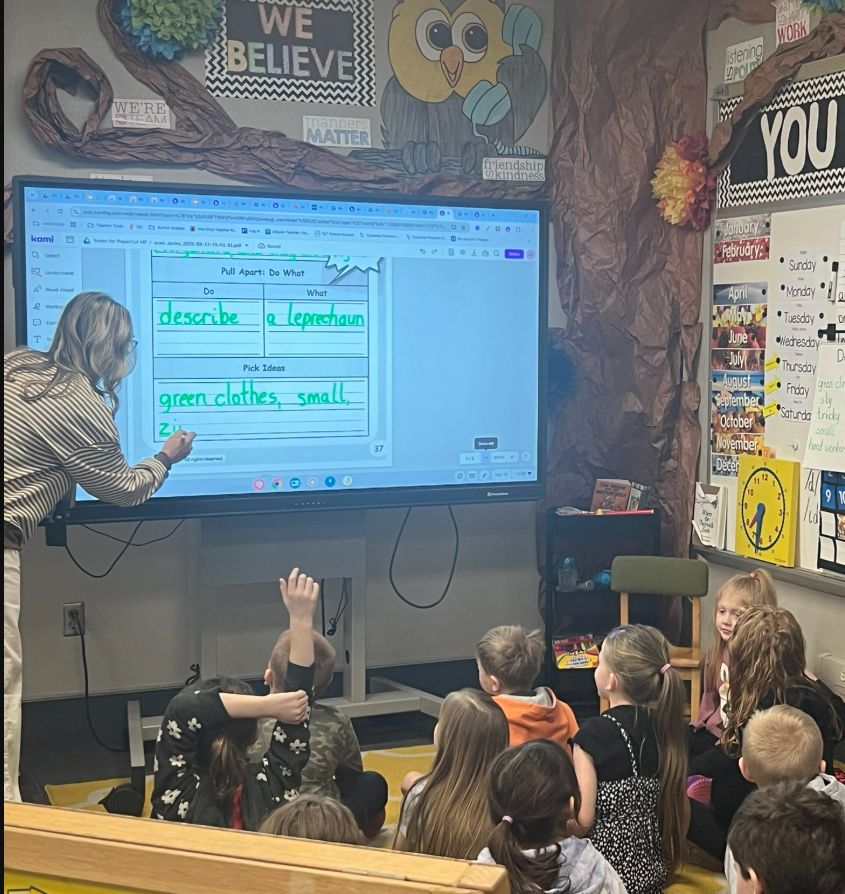 teacher in front of class writing on electronic board teacher in front of class writing on electronic board