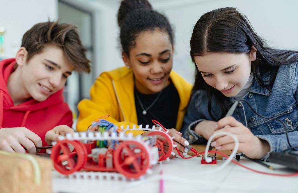 3 students working on robot in STEM class