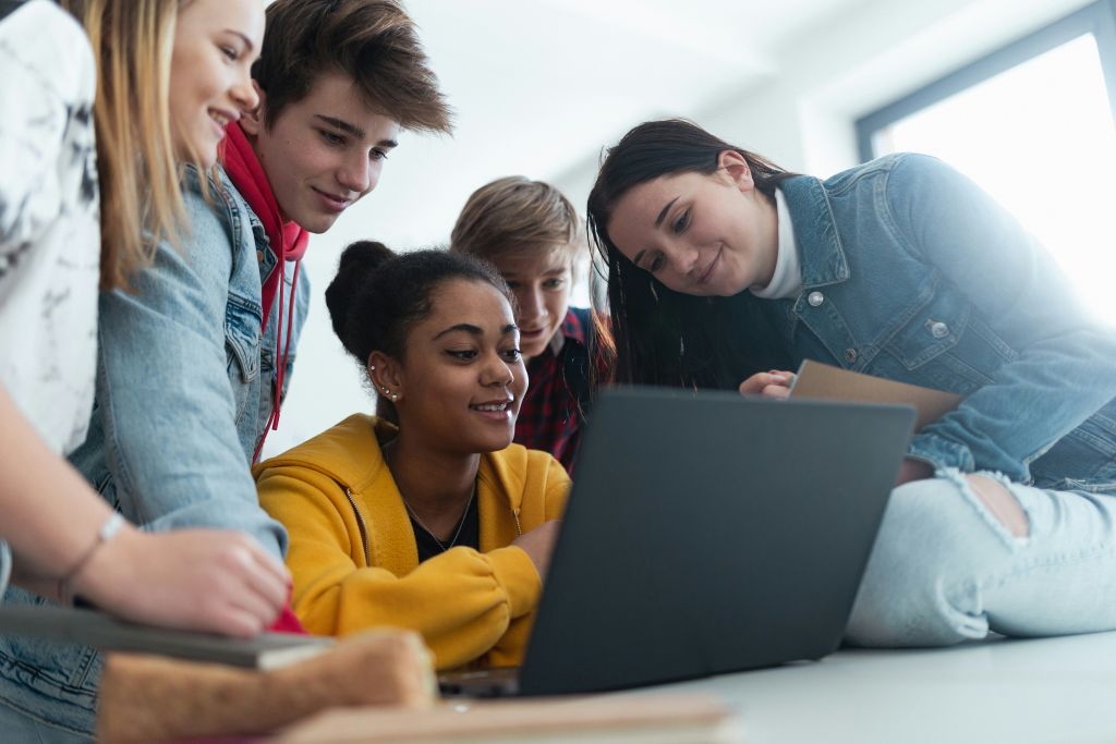 teens gathered around a computer