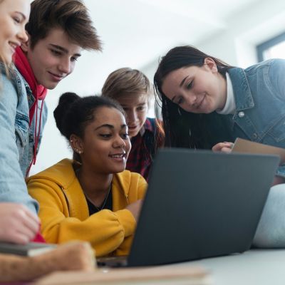 teens gathered around a computer