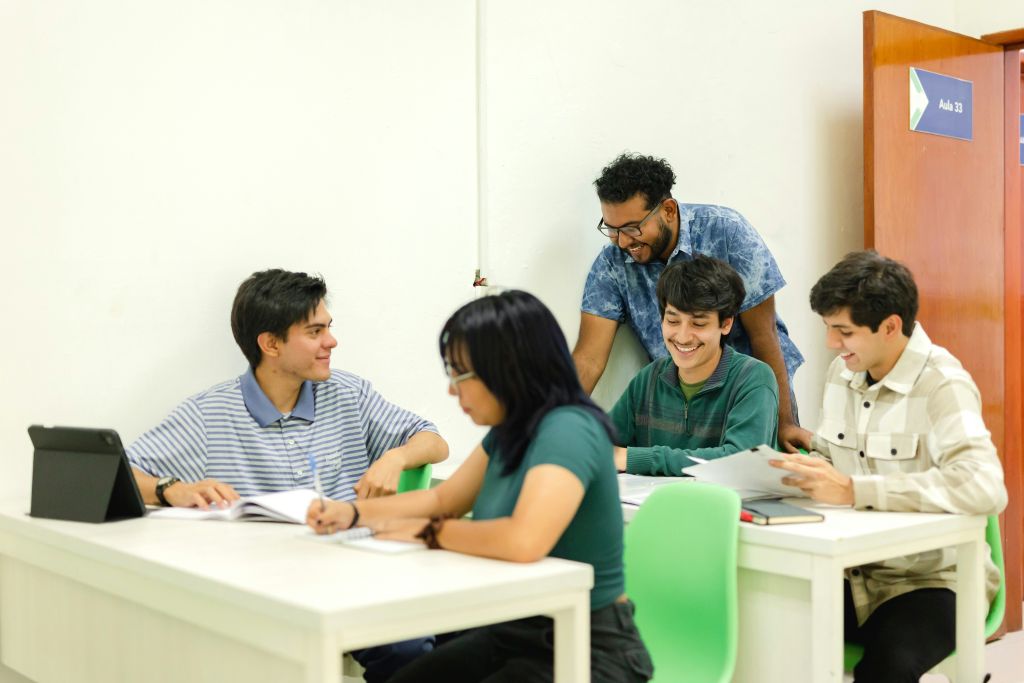 5 adults working together at 2 tables
