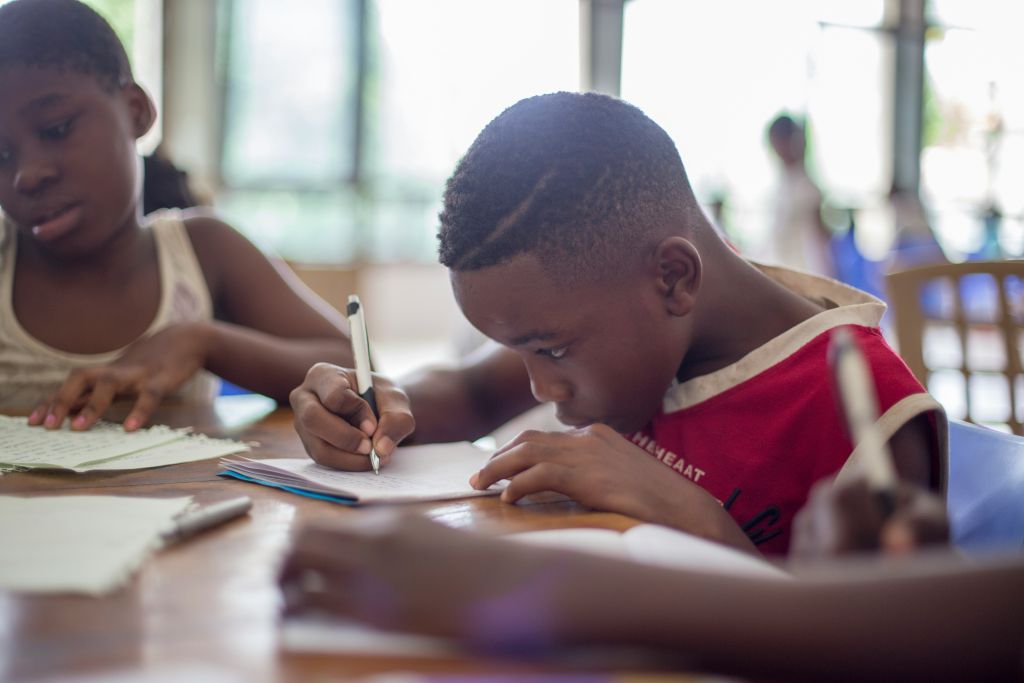 Boy writing on notebook paper
