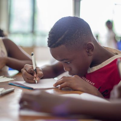 Boy writing on notebook paper