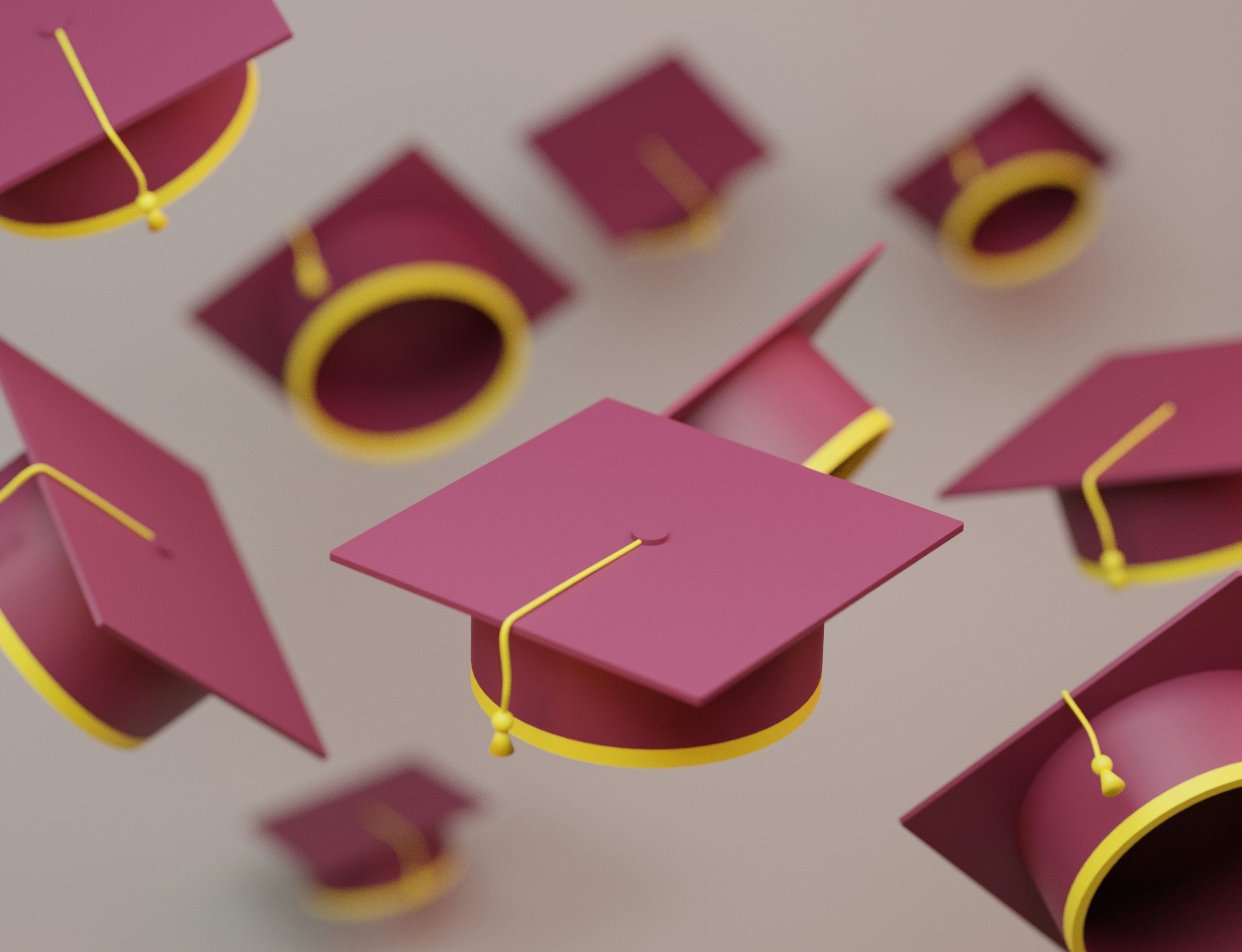 valeria-nikitina-7-ywKydIPaE-unsplash (1) Multiple burgundy graduation caps in the air