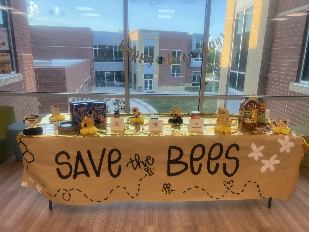 A display table with a "save the bees" banner handing on the front